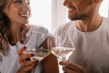Wonderful curly woman celebrating anniversary with boyfriend. Couple drinking champagne.