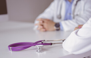 Two doctors discussing and working together in a medical office