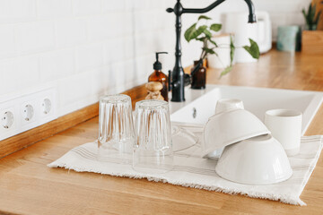 Clean glasses and dishes on towel on the kitchen table after washing