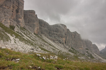 On route to Rifugio Citta di Fiume from Passo Giau over grassy, wild and rocky terrain on stage six of the classic Alta Via 1 trek, Dolomites, Belluno province, South Tyrol, Italy.