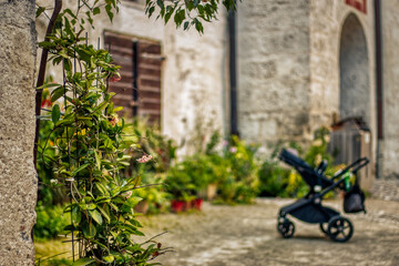 Fototapeta na wymiar Stroller on the courtyard with plants and vases