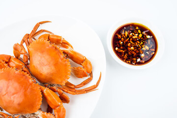 A dish of delicious steamed red sturgeon crab on white background