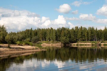 Fototapeta na wymiar Forest lake view, smooth surface of a lake with clouds reflected, shining level of a forest lake