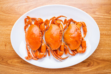 A dish of delicious steamed red sturgeon crab on wooden table
