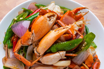 A dish of delicious spicy blue crabs on a wooden table