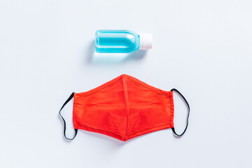 Fashionable protective face mask and hand sanitizer gel on white background, top view. New normal...
