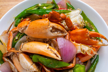 A dish of delicious spicy blue crabs on a wooden table
