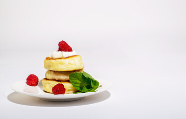 Delicious and healthy cheesecakes with sour cream and raspberries, with a Cup of black coffee. 