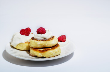 Delicious and healthy cheesecakes with sour cream and raspberries, with a Cup of black coffee. 