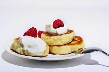 Delicious and healthy cheesecakes with sour cream and raspberries, with a Cup of black coffee. 