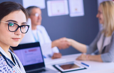 Doctor and patient discussing something while sitting at the table . Medicine and health care concept