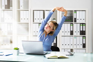 Woman Stretches At Office Desk