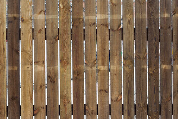 The texture of weathered wooden wall. Aged wooden plank fence of vertical flat boards