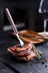Beef Steak on a dark plate with rosemary and pepper
