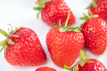 several strawberries are removed from the glare on a white background