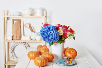 Autumn harvest pumpkin background. Pumpkins and flowers on table. Thanksgiving table. Copy space. Halloween or seasonal autumnal. Design mock up. Greeting card. Fall kitchen.
