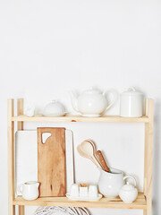 Kitchen utensils, tools, chef accessories and dishware on wooden shelf. Kitchen rustic interior. Home kitchen decor concept. Copy space. Contemporary kitchenware background