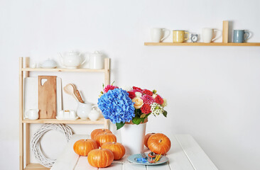 Autumn harvest pumpkin background. Pumpkins and flowers on table. Thanksgiving table. Copy space. Halloween or seasonal autumnal. Design mock up. Greeting card. Fall kitchen.