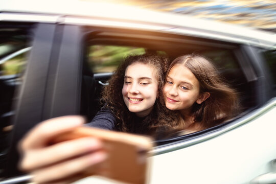 young girls in the car taking a selfie photo of themselves
