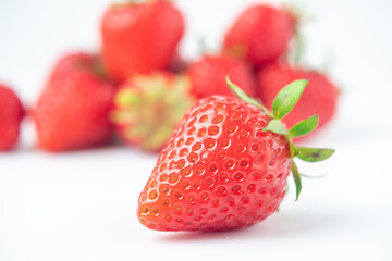several strawberries are removed from the glare on a white background