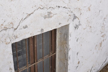Fototapeta na wymiar Ventana de casa antigua con pared blanca con textura