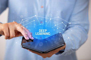 Businessman holding a foldable smartphone with DEEP LEARNING inscription, new technology concept