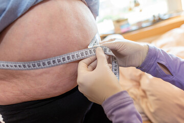 Woman measures the waistline of a fat woman