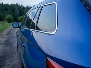 Close up rear-side view of blue car in nature background