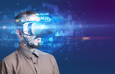 Businessman looking through Virtual Reality glasses with QUALITY inscription, innovative technology concept