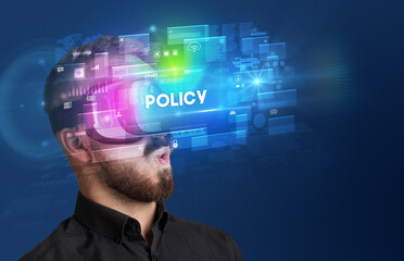Businessman looking through Virtual Reality glasses with POLICY inscription, innovative security concept