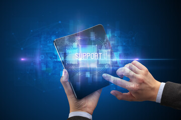 Businessman holding a foldable smartphone with SUPPORT inscription, new technology concept