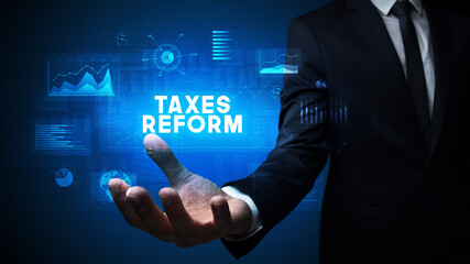 Hand of Businessman holding TAXES REFORM inscription, business success concept
