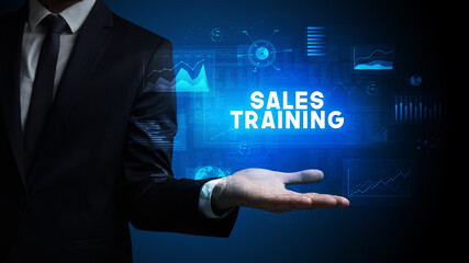 Hand of Businessman holding SALES TRAINING inscription, business success concept