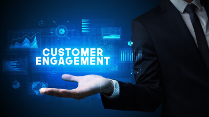 Hand of Businessman holding CUSTOMER ENGAGEMENT inscription, business success concept