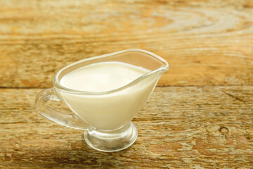 cream in a jug on a wooden table.