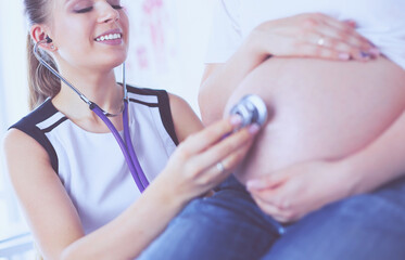 Young female doctor examining pregnant woman at the clinic.