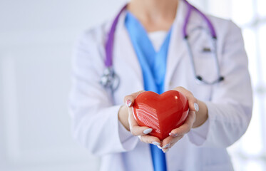 Doctor with stethoscope holding heart, isolated on white background