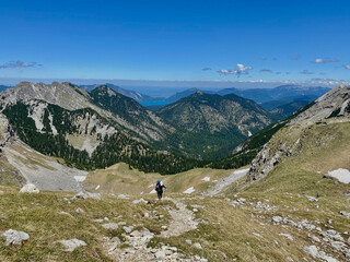 Fototapeta na wymiar Man hiking in alps, mountain view with blue sky, Soiernspitz, Bavaria, Germany