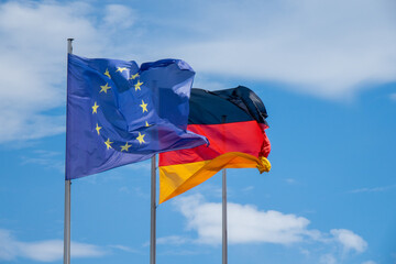 Flaggen von Deutschland und der Europäischen Union wehen im Wind in Berlin. 