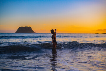 Fototapeta na wymiar young woman on the beach at sunrise