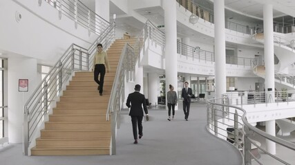 Business people wearing face mask walking and meeting in modern corporate office lobby during Coronavirus pandemic - Powered by Adobe