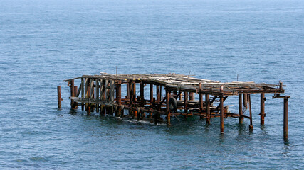 Metal piles of the old pier in the Black Sea water