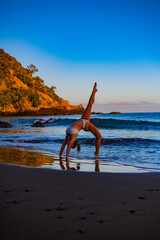 Fototapeta na wymiar young woman doing yoga on the beach