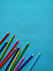 Back to school concept. Top vertical view of color pencils on blue background.