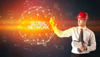 Handsome businessman with helmet drawing GLOBAL NETWORK inscription, social construction concept