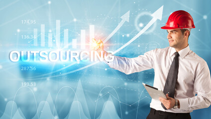 Young businessman with helmet drawing OUTSOURCING inscription, modern business technology concept
