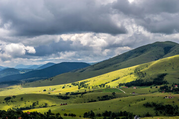 Fototapeta na wymiar The landscape of Zlatibor Mountain in Serbia. Green meadows and hills under the blue sky with clouds in the summertime
