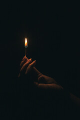 Woman's hand holding a lighted match