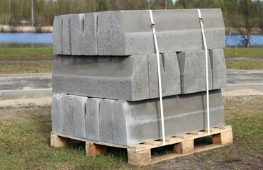 Gray stone slabs for construction stand on top of each other on the grass in summer. Selective focus. Construction and construction.