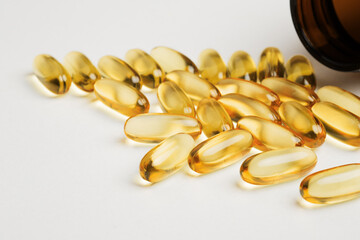 Omega-3 fish oil capsules are poured out of the bottle. Vitamins and dietary supplements